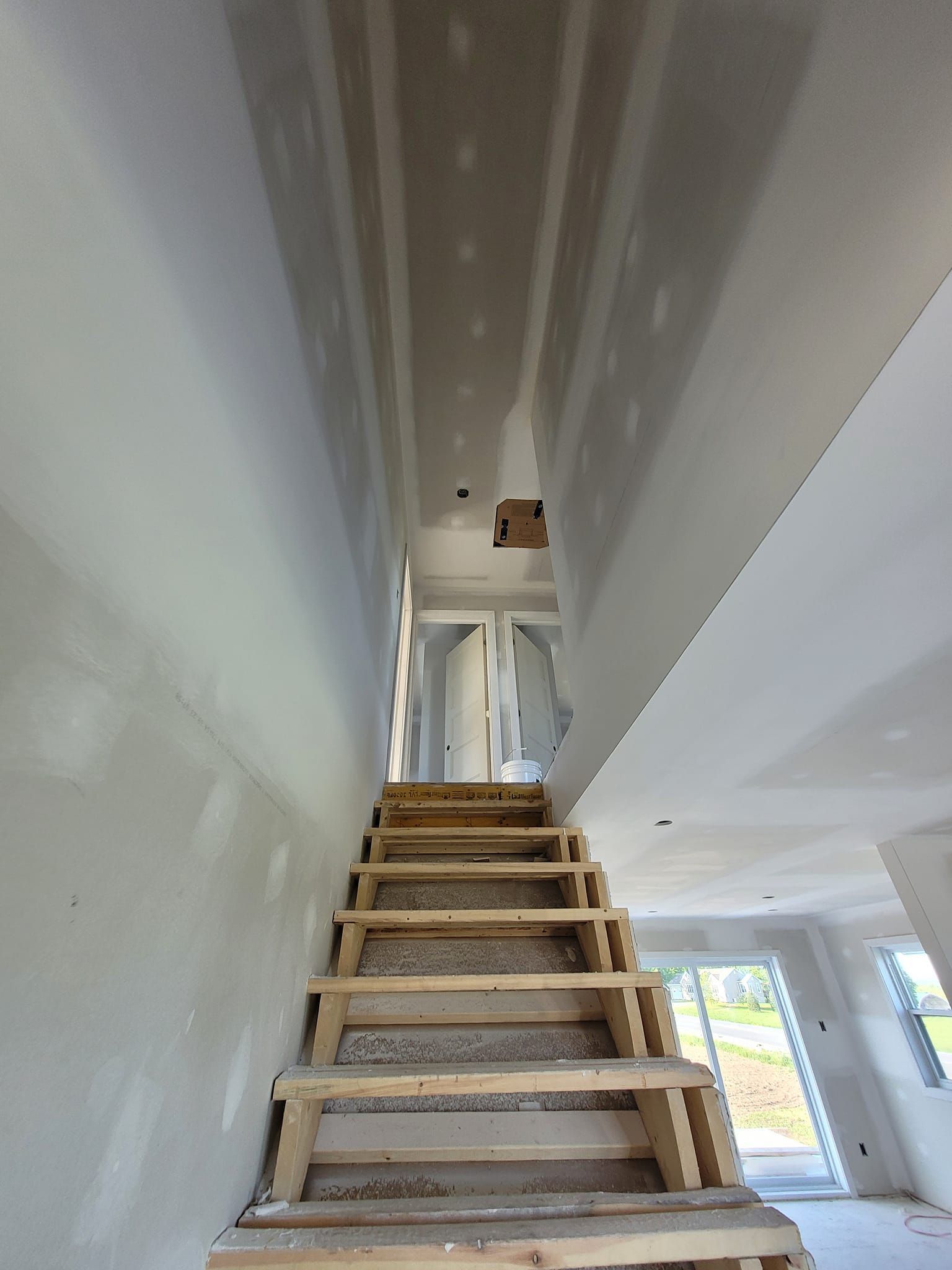 Un escalier en bois est en cours de construction dans une maison en construction.