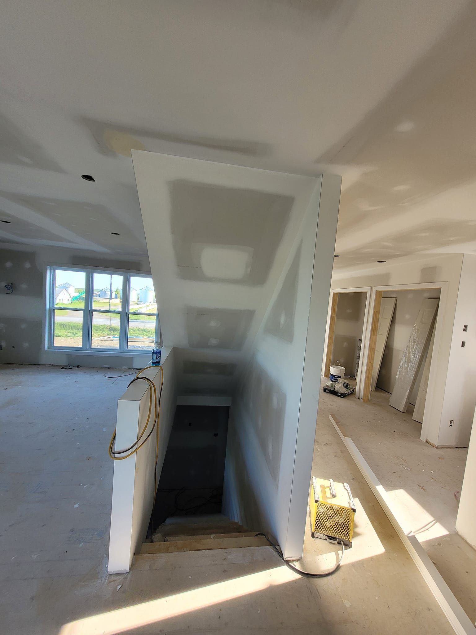 Une pièce avec un escalier menant à un sous-sol en construction.