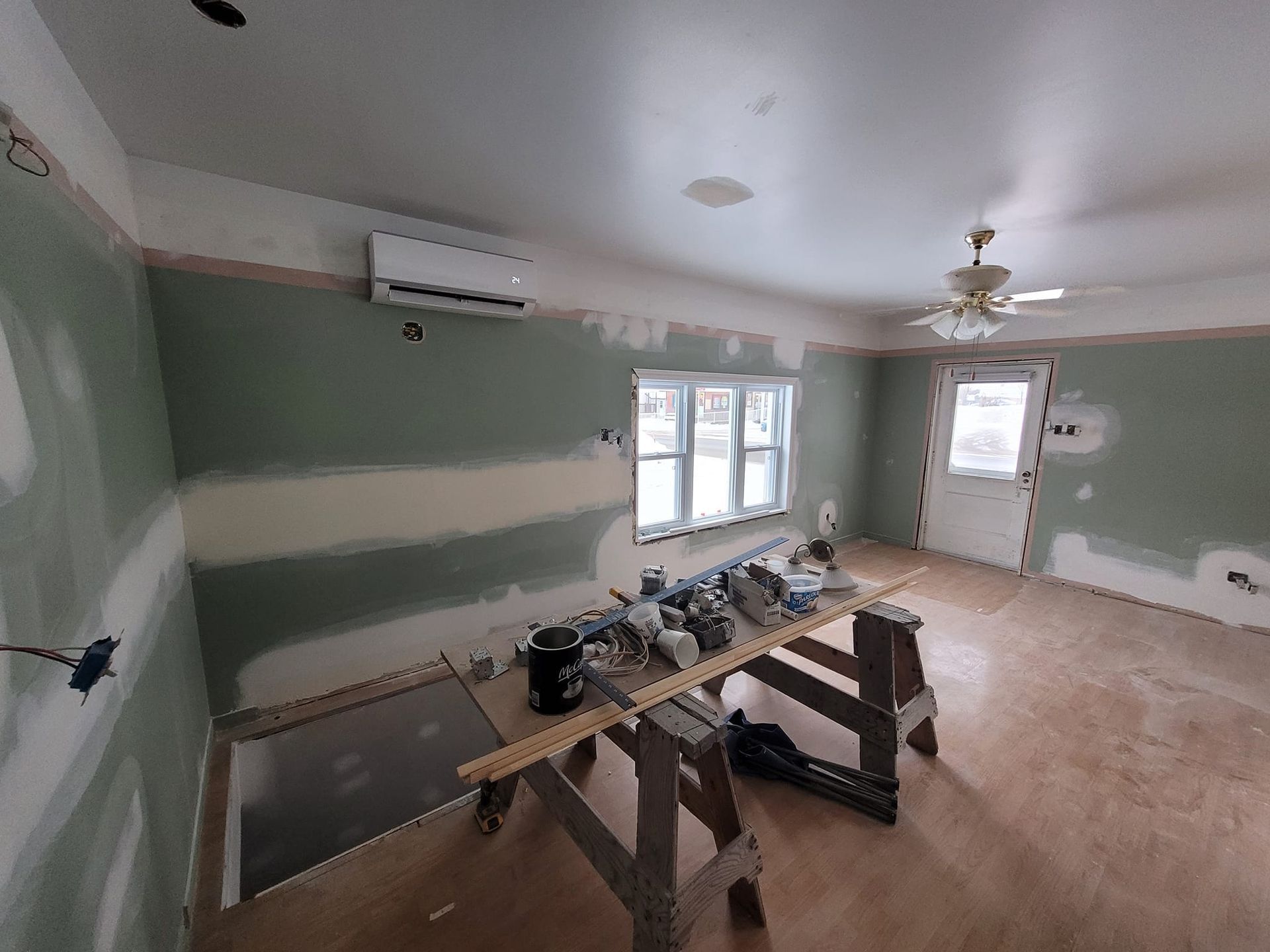 Une pièce avec une table en bois et un ventilateur de plafond.