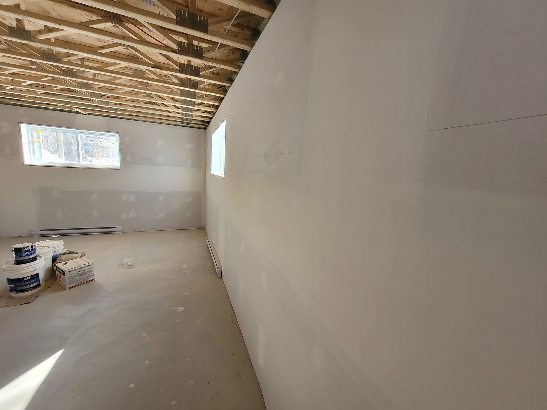 Une pièce vide avec un mur blanc et une fenêtre.