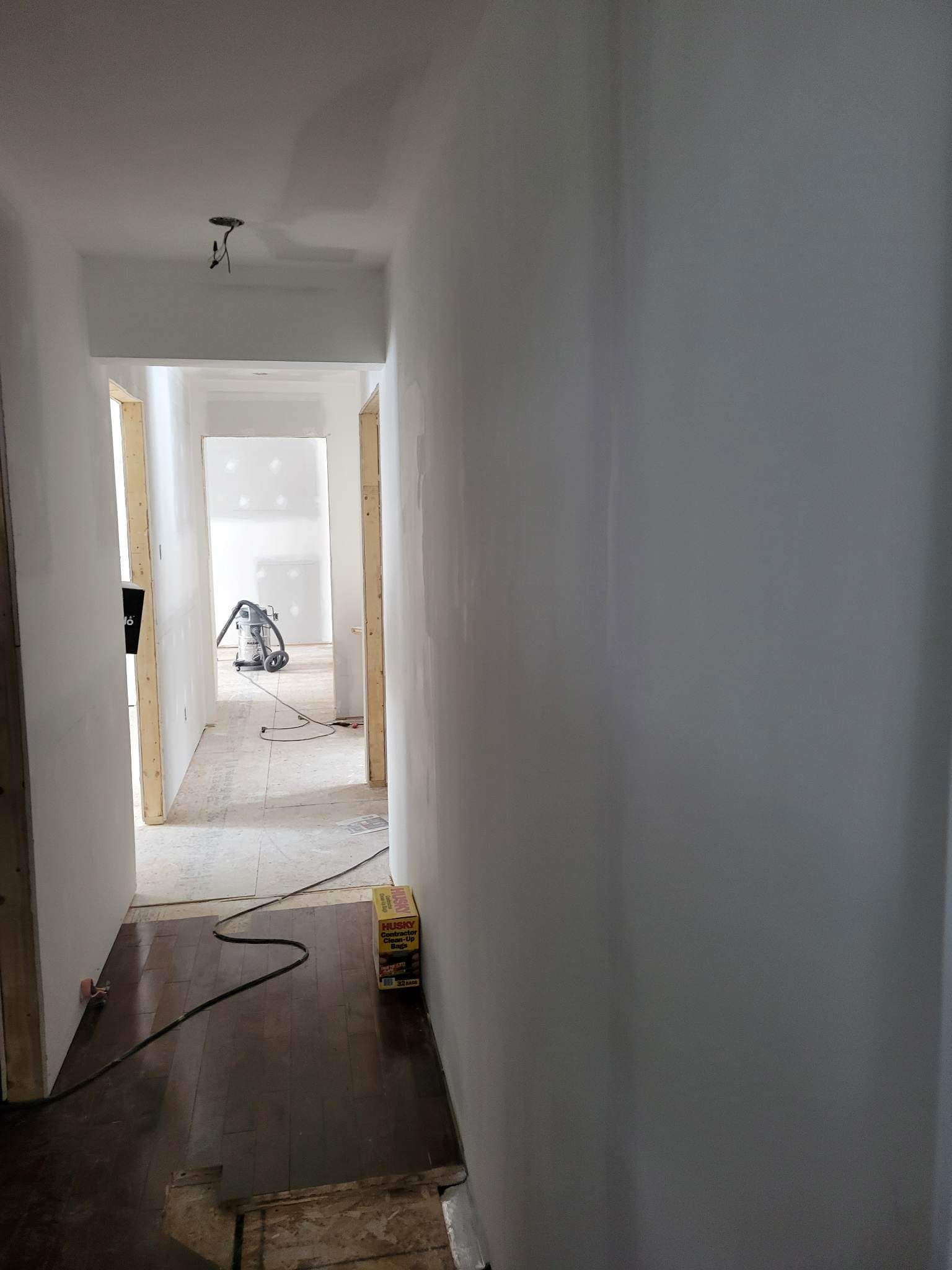 Un long couloir avec un aspirateur sur le sol.