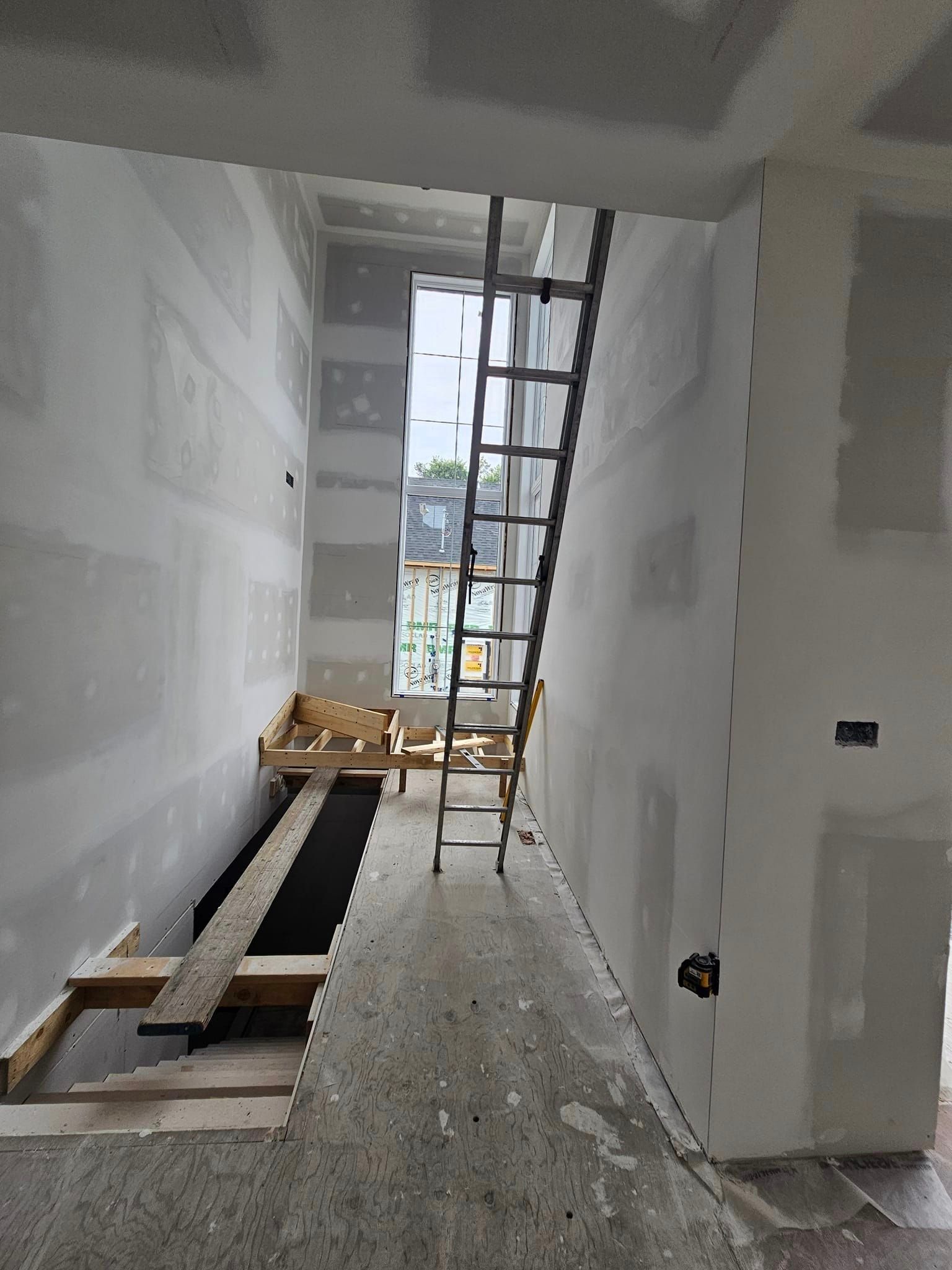 Une échelle est suspendue au plafond d'un bâtiment en construction.