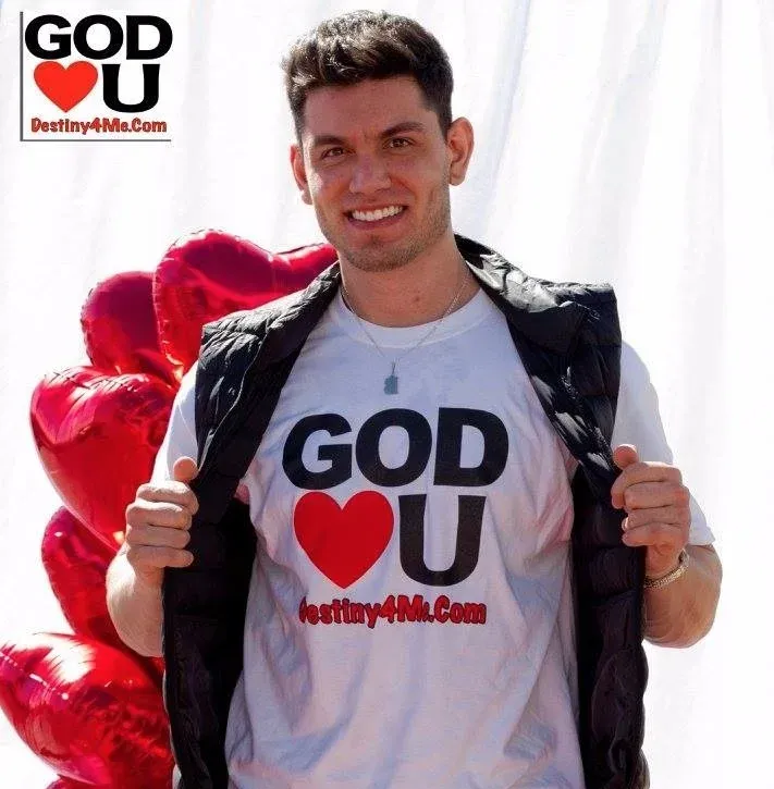 A man wearing a shirt that says god loves you