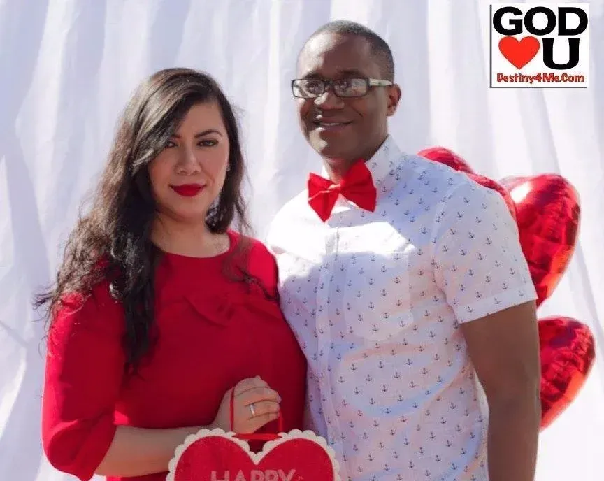 A man and a woman are posing for a picture with a sign that says god loves you
