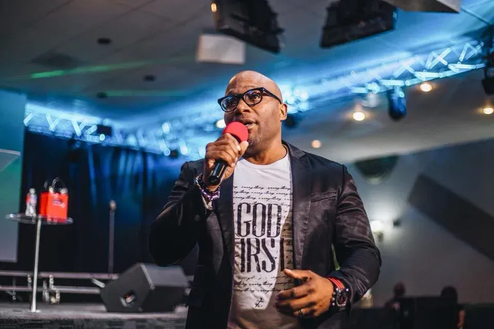 A man is standing on a stage holding a microphone.