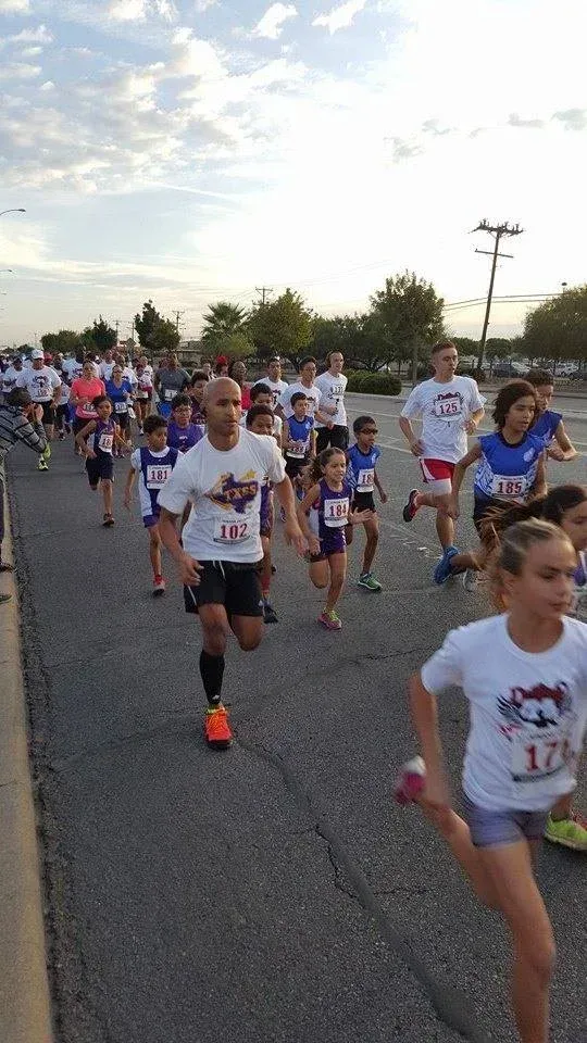 A group of people are running down a street.