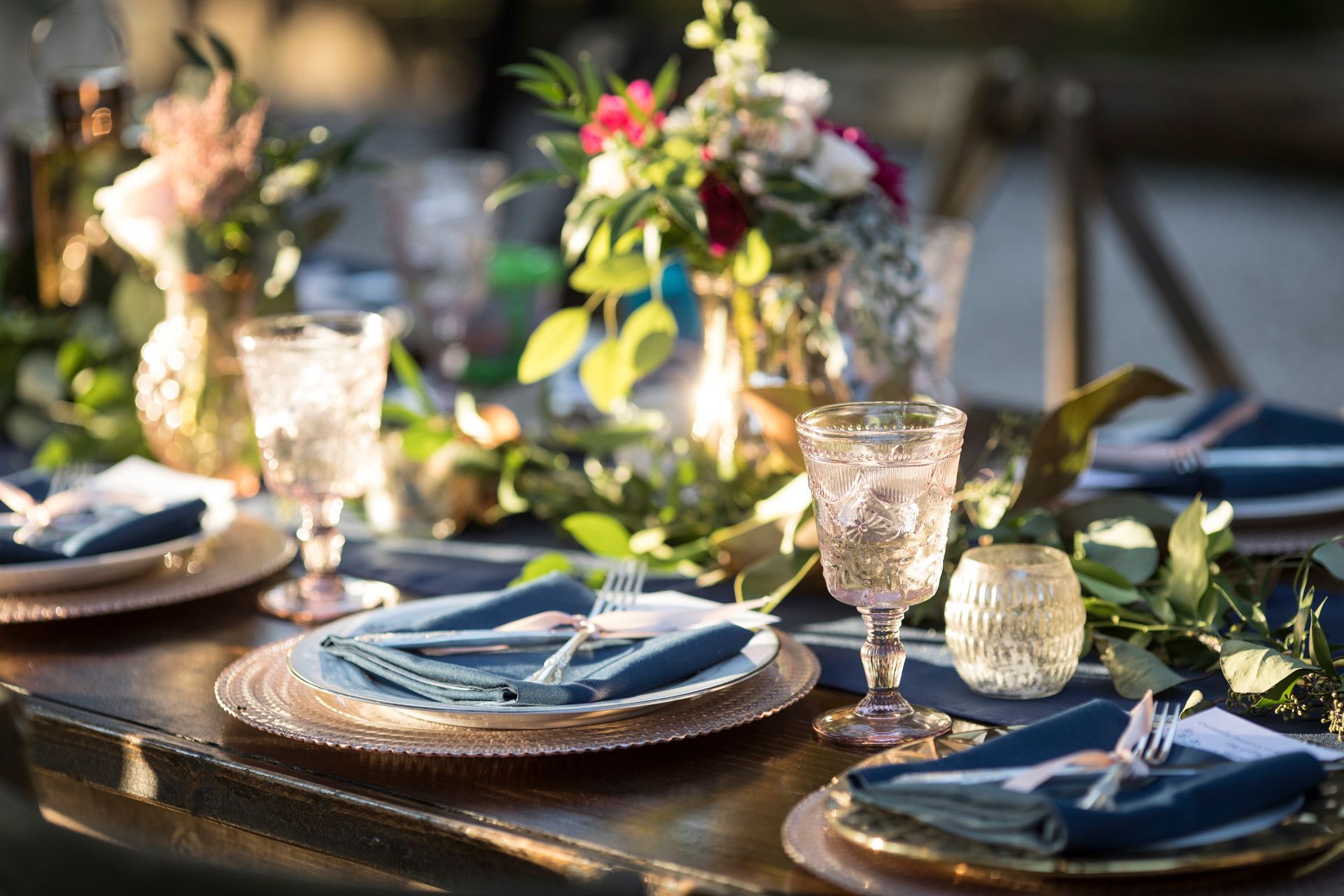 Beautiful tablescape with place settings, blue linens, and crystal goblets