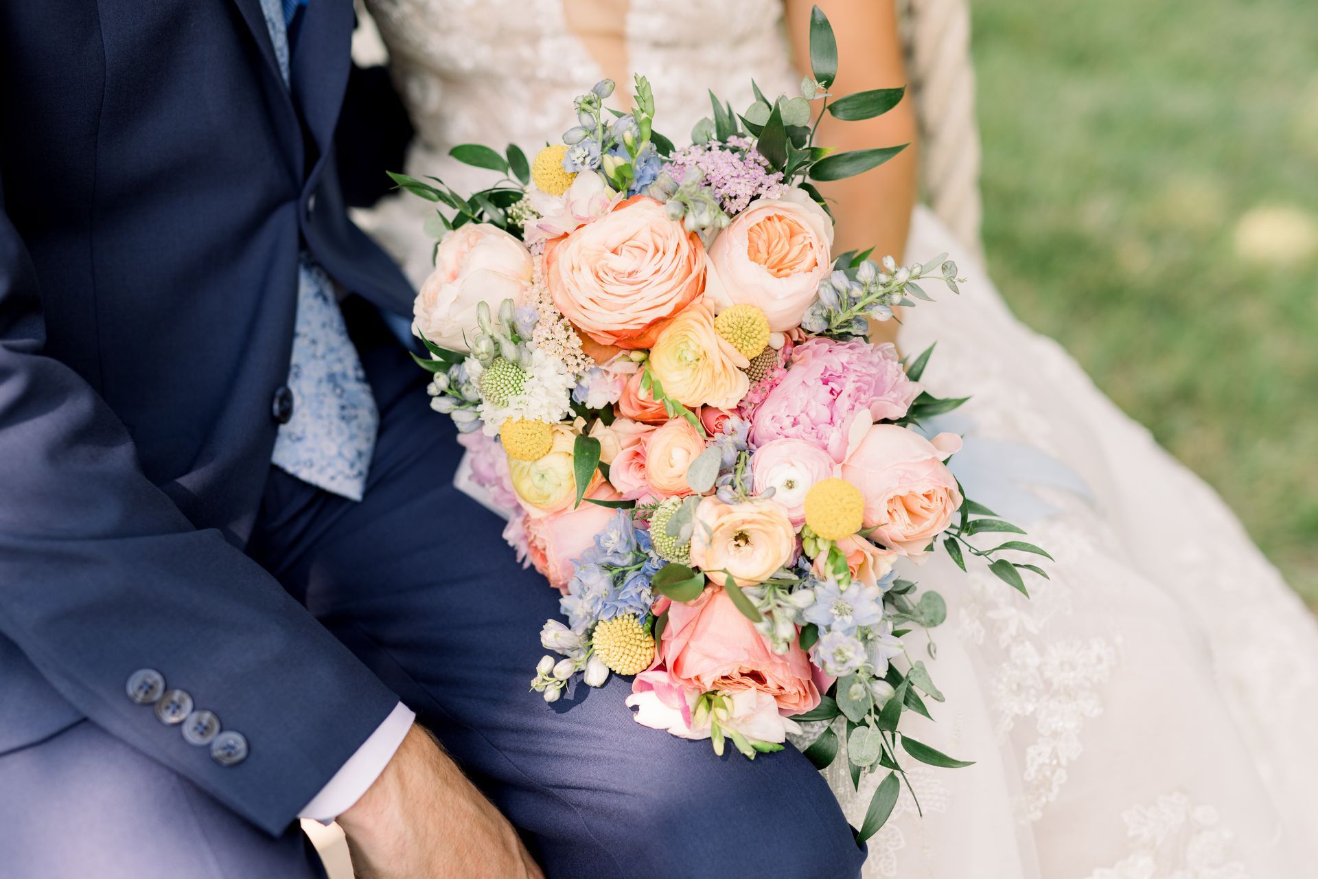 Bride and groom holding a bouquet of colorful flowers on their wedding day