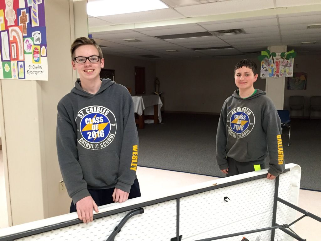 Two boys in gray hoodies, smiling indoors. 