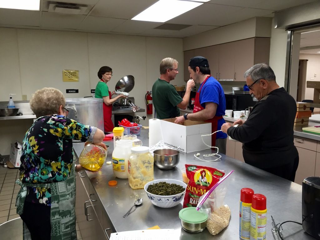 A group of people in a kitchen working together. 