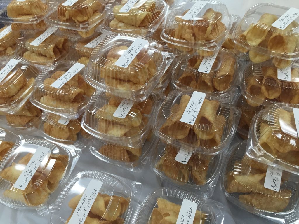 Stacks of clear plastic containers filled with golden-brown, crispy pastries.