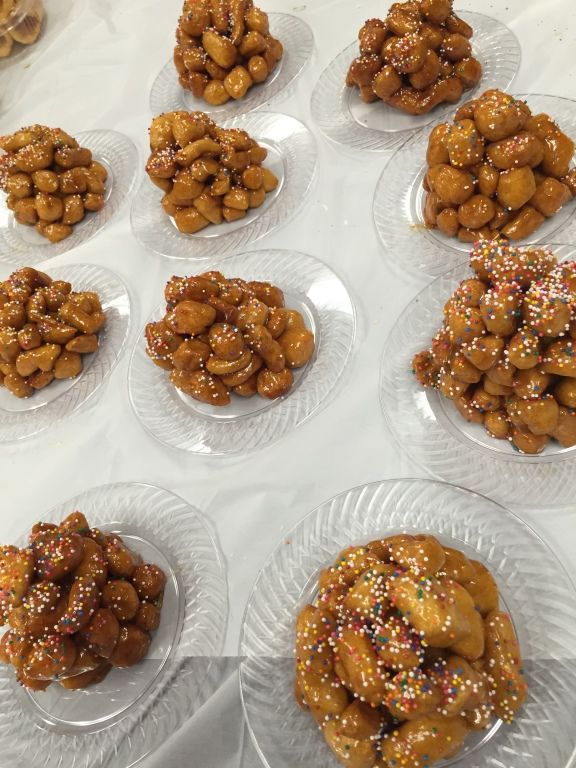 Ten clear plates, each holding a mound of glazed dough balls adorned with colorful sprinkles.
