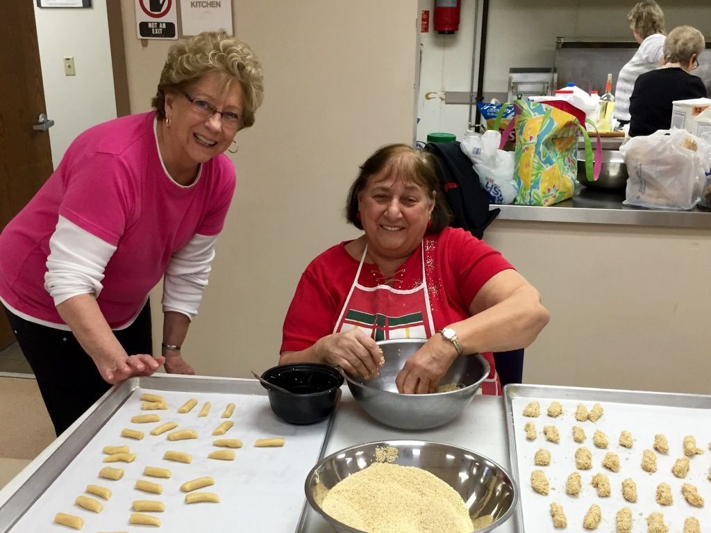 Two women smiling in a kitchen making cookies.