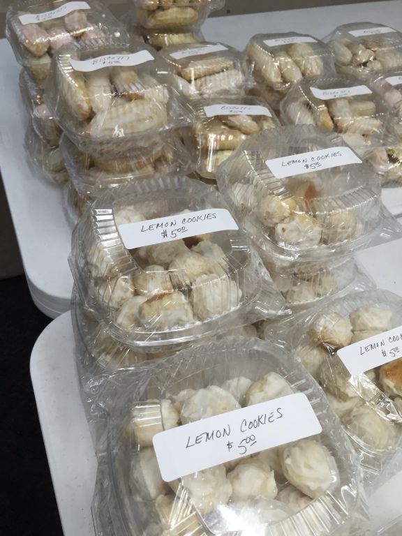 Stacks of clear plastic containers filled with glazed lemon cookies.