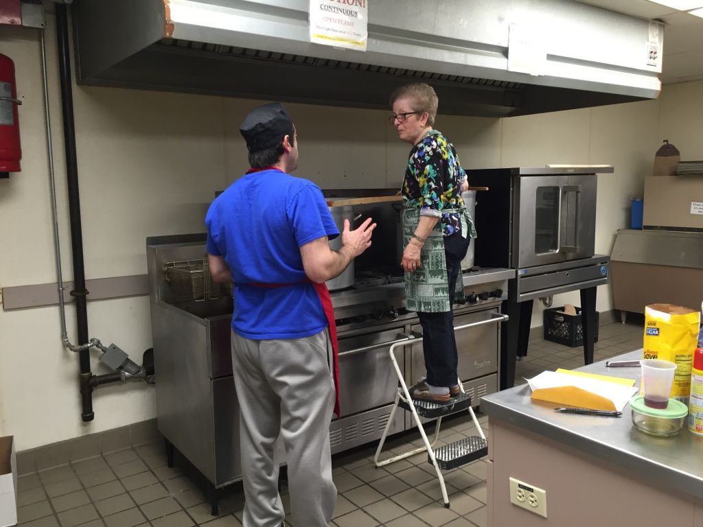 Two people in a commercial kitchen.