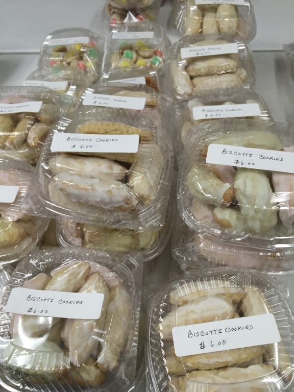 Plastic containers filled with frosted biscotti cookies.