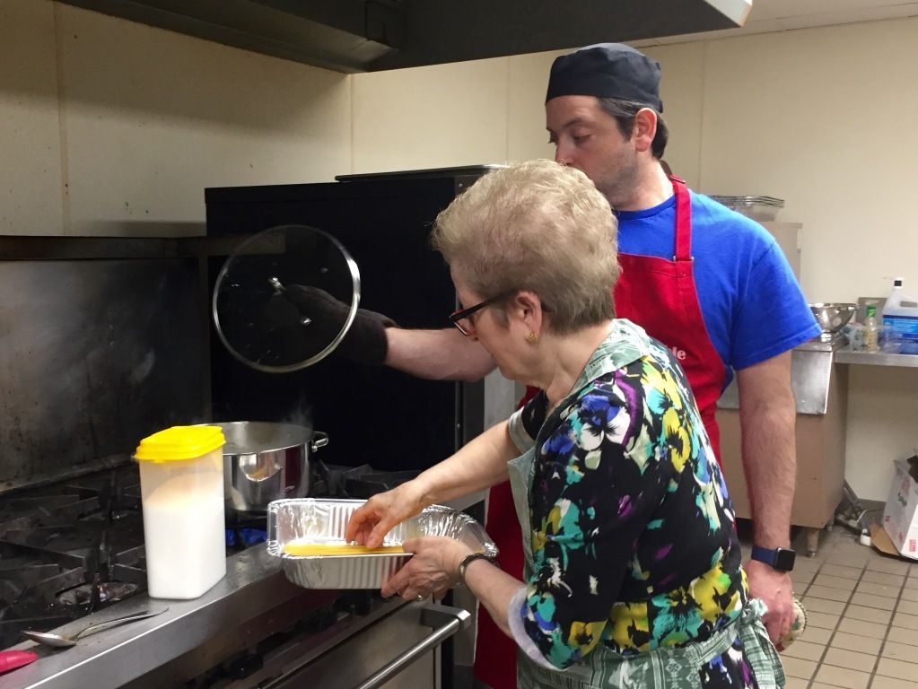 Two people in a kitchen cook together. 