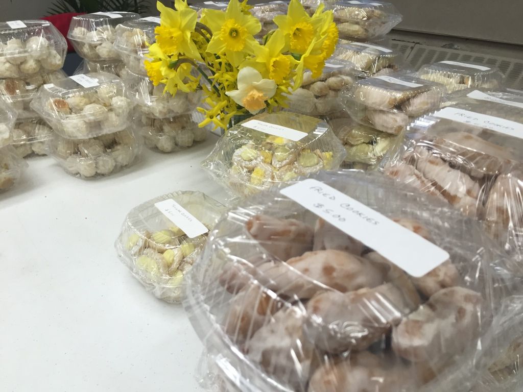 Plastic containers filled with assorted cookies are neatly stacked on a table. 