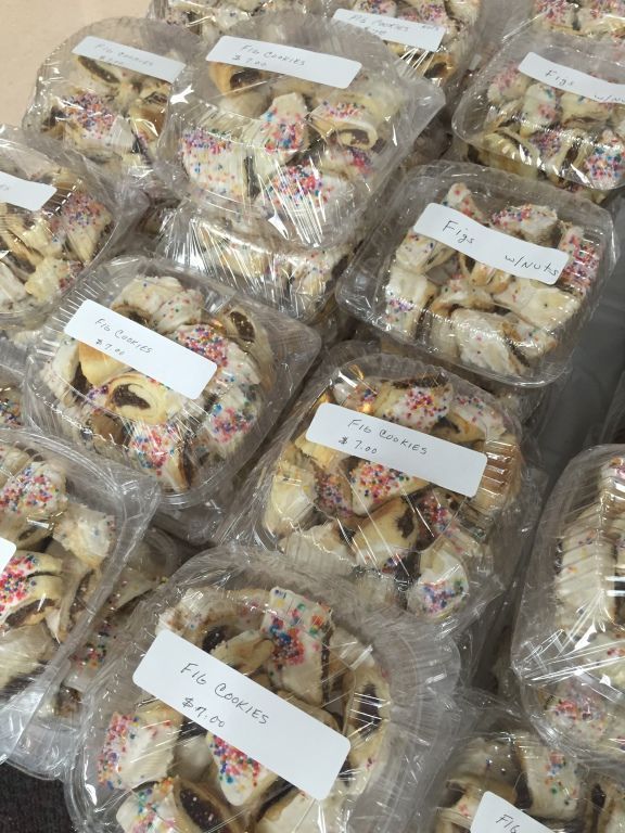 Plastic containers filled with fig cookies, icing, and colorful sprinkles.