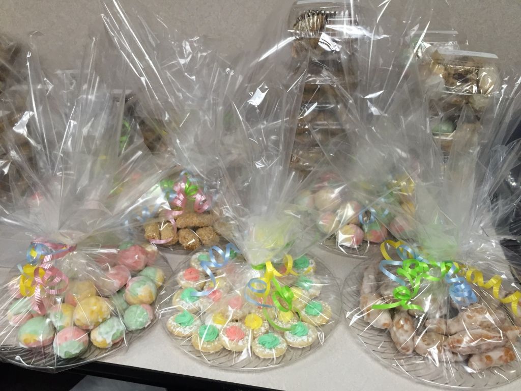 Colorful trays of cookies wrapped in clear cellophane, tied with pastel ribbons.