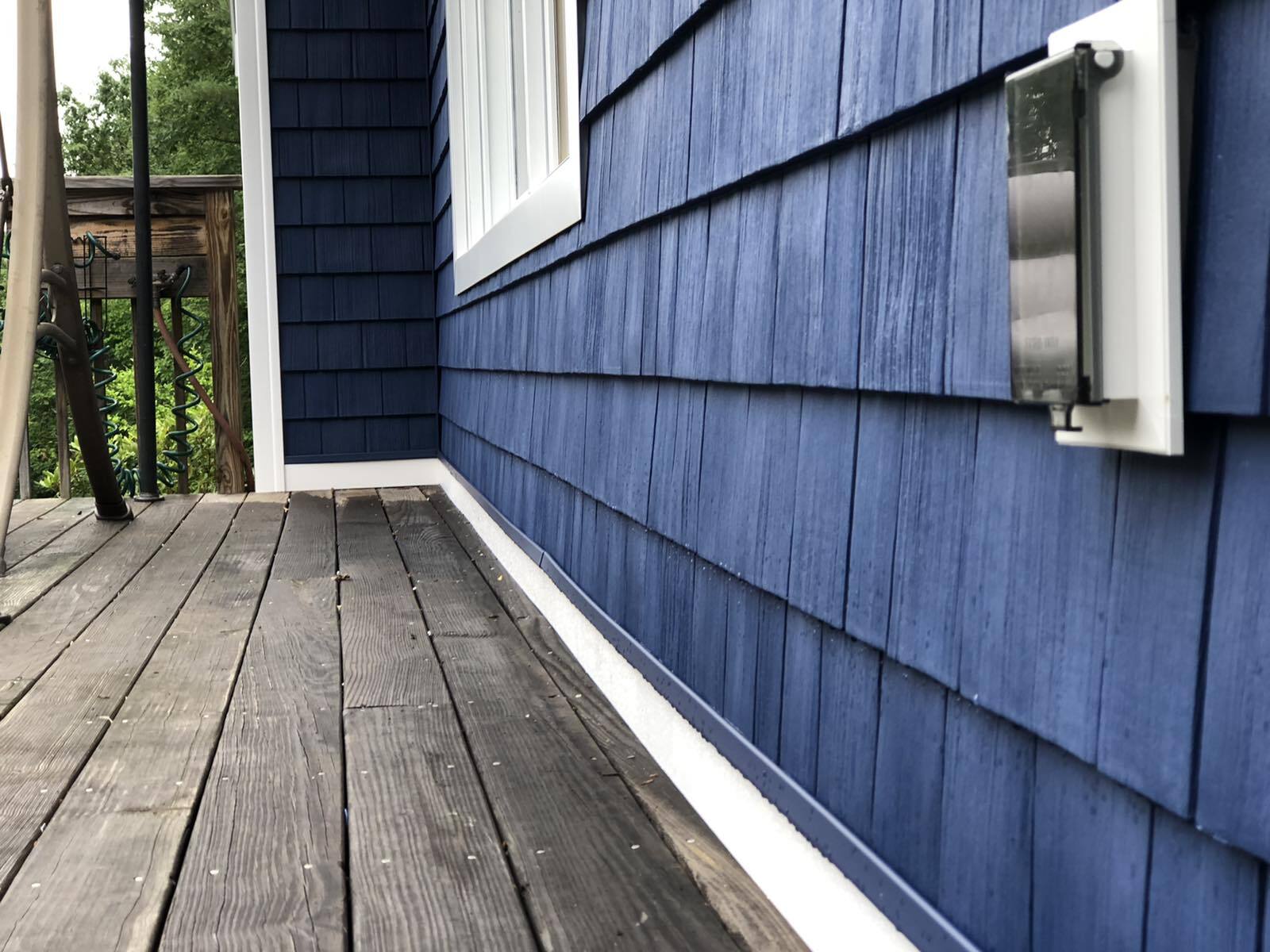 Close-up of new dark blue shake vinyl on white trim for customers home in Blandford, Massachusetts.