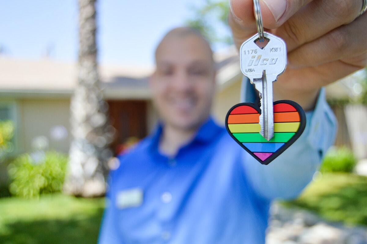 Tenant holding a house key on a rainbow keychain