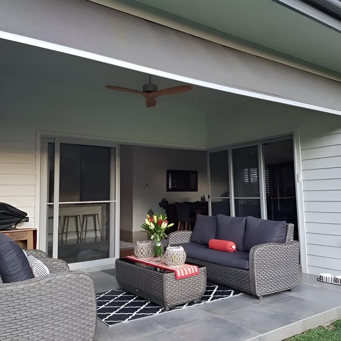 A Person is Sitting in Front of a Window With a Reflection of Trees in It — Port Blinds & Awnings In Port Macquarie, NSW