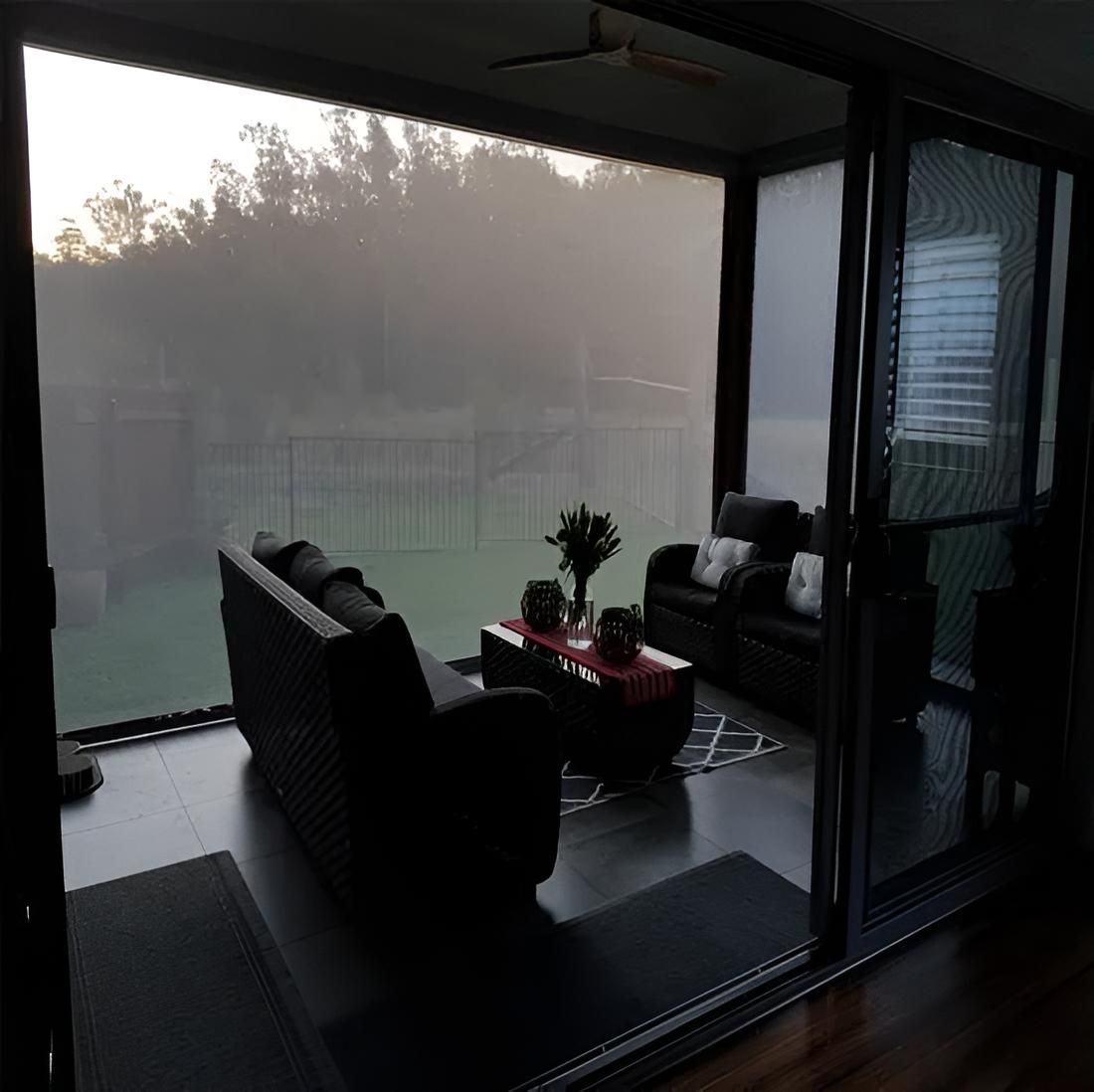 A Living Room With a Couch and Chairs and a Sliding Glass Door — Port Blinds & Awnings In Port Macquarie, NSW
