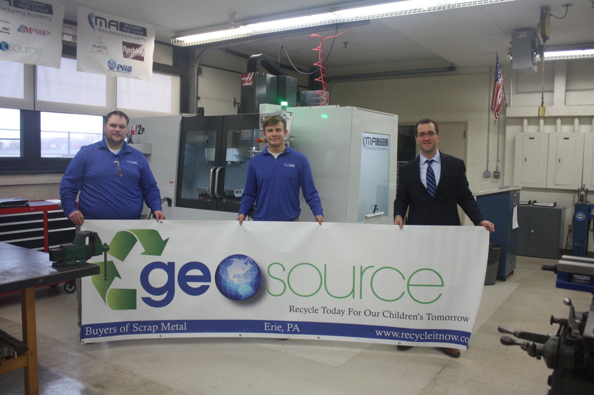 Three men are holding a sign that says geosource