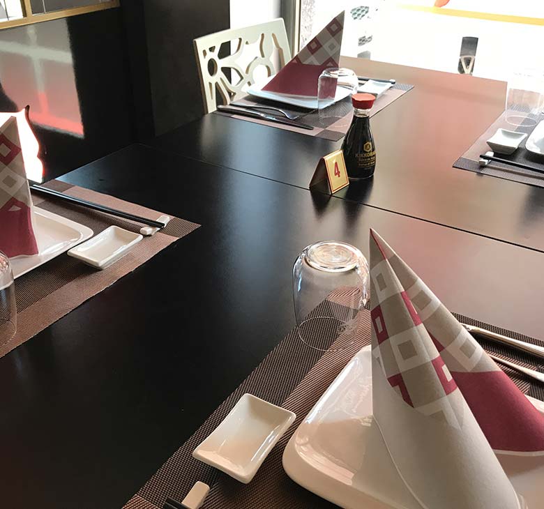 Tavolo del ristorante orientale con soia e bacchette cinesi