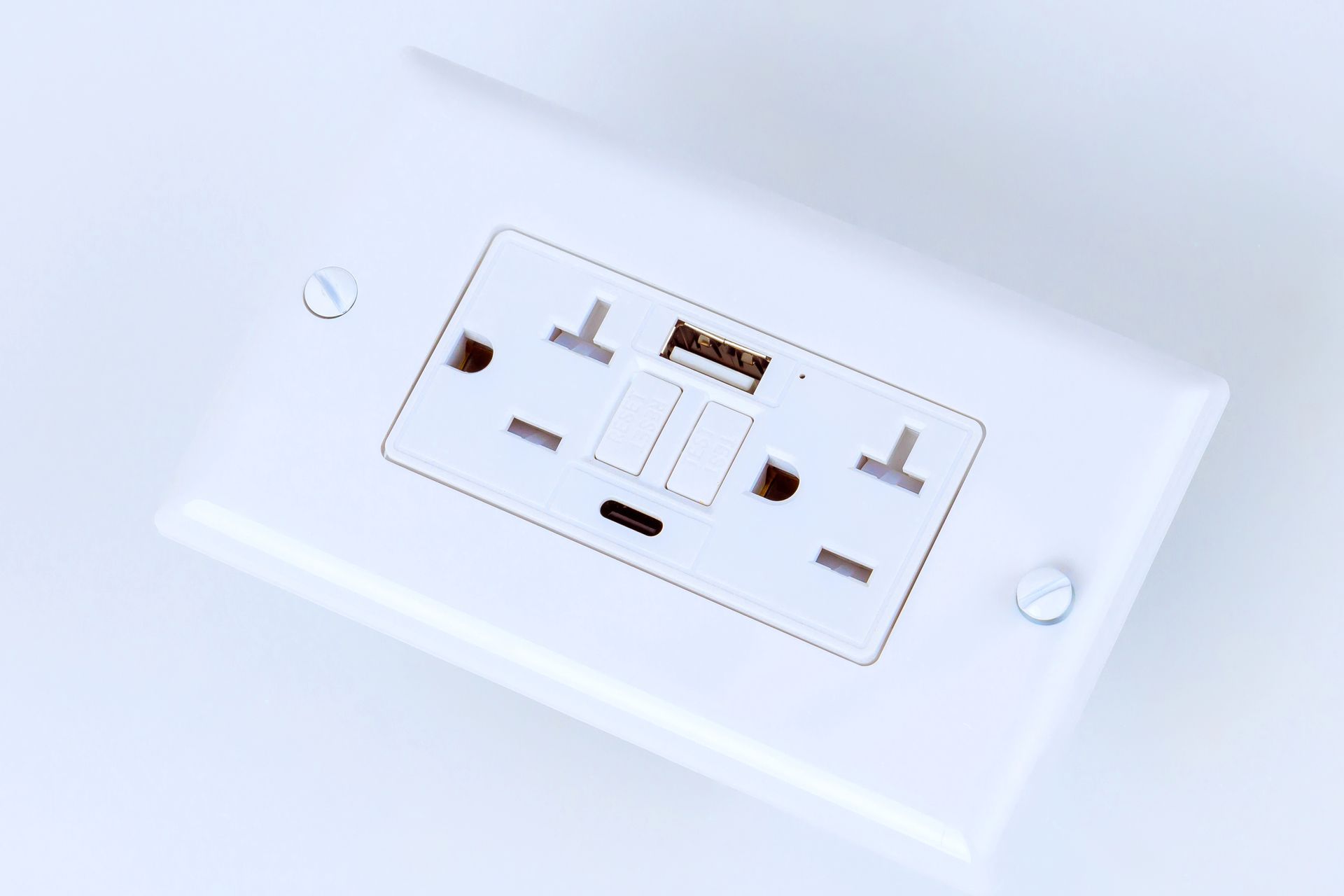 White wall outlet with two plugs and two USB ports.