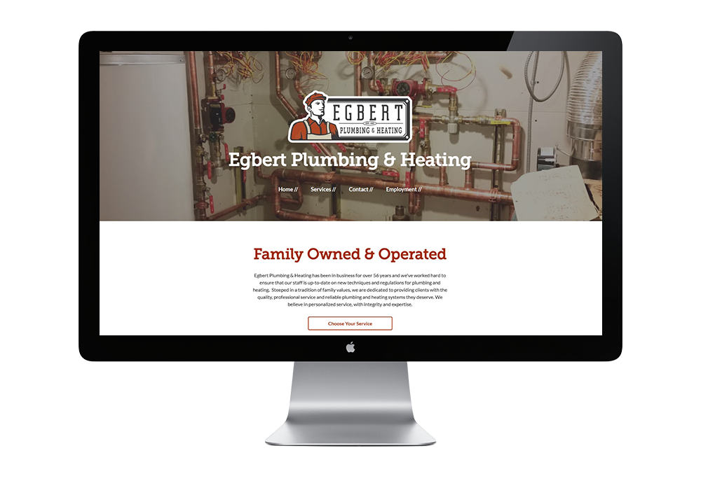A computer monitor is displaying a website for a plumbing and heating company.