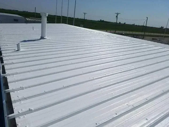 A white metal roof with a chimney on top of it.