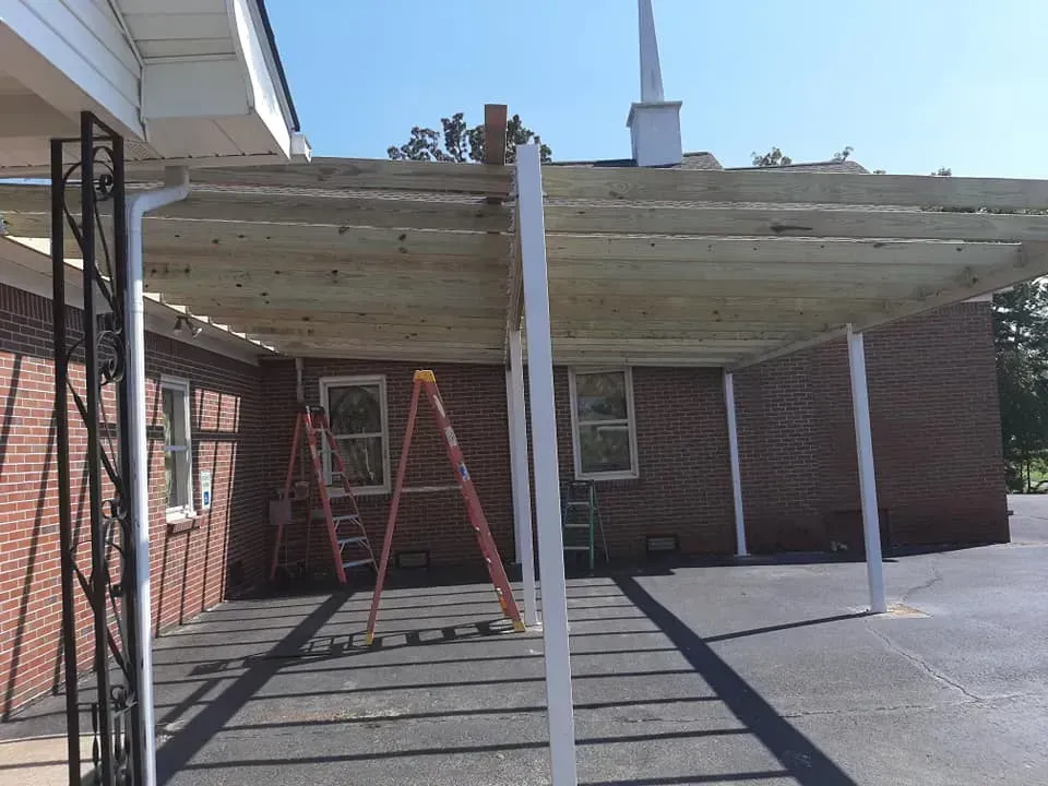 A wooden structure is being built in front of a brick building