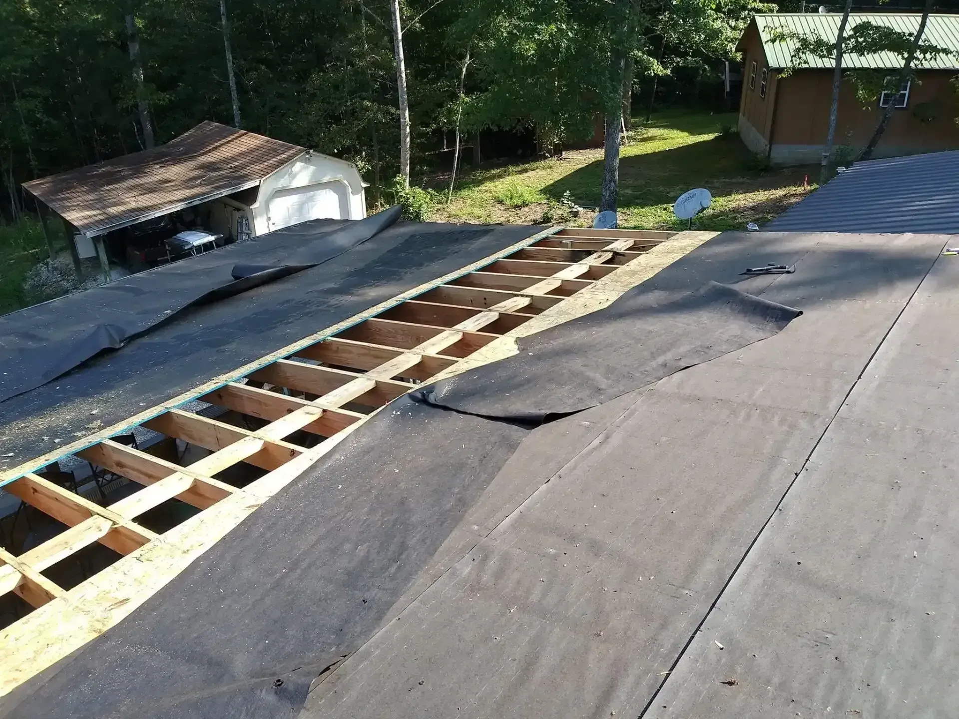 The roof of a house is being remodeled with a wooden frame.