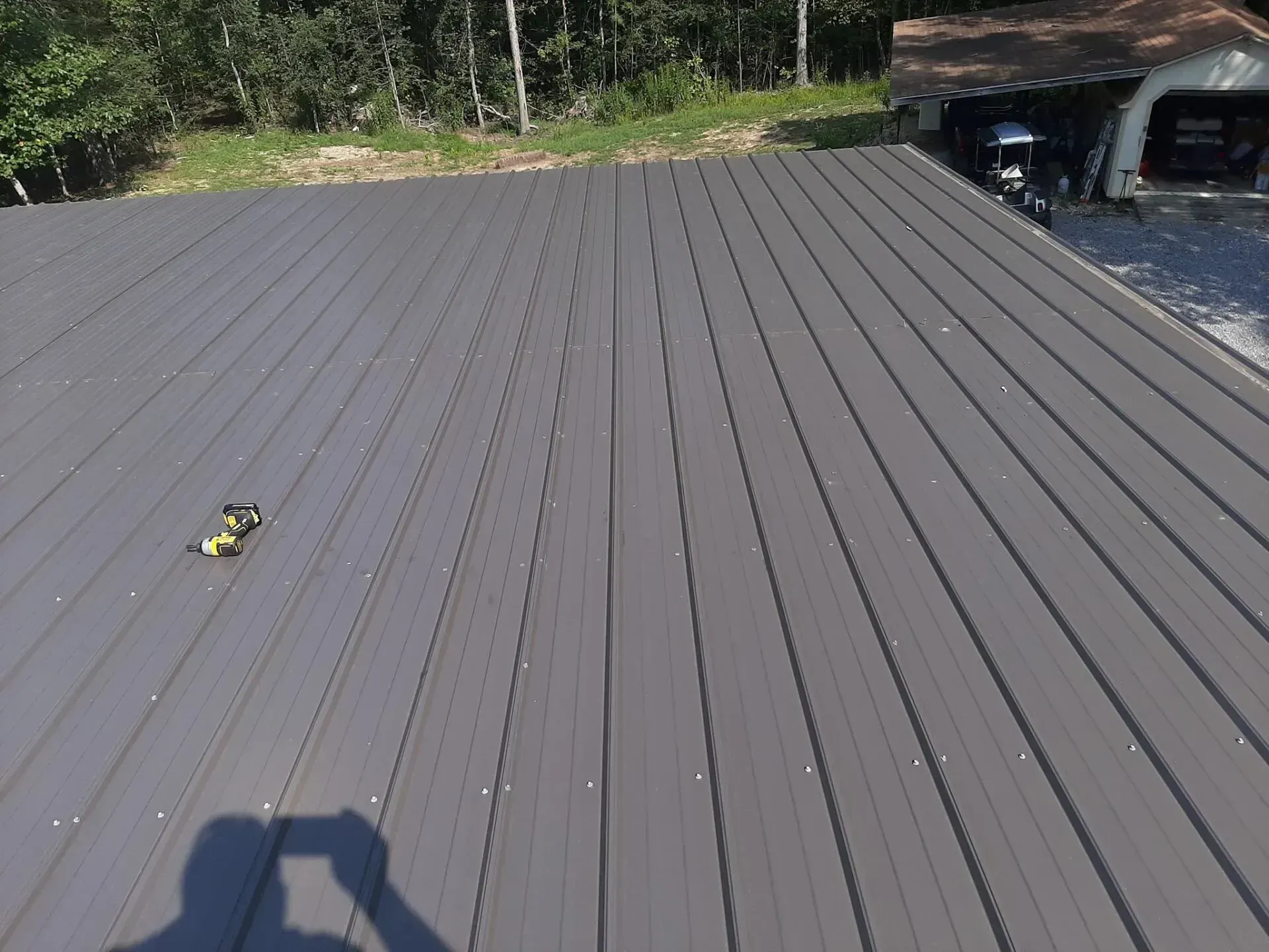 A roof with a shadow of a person taking a picture of it