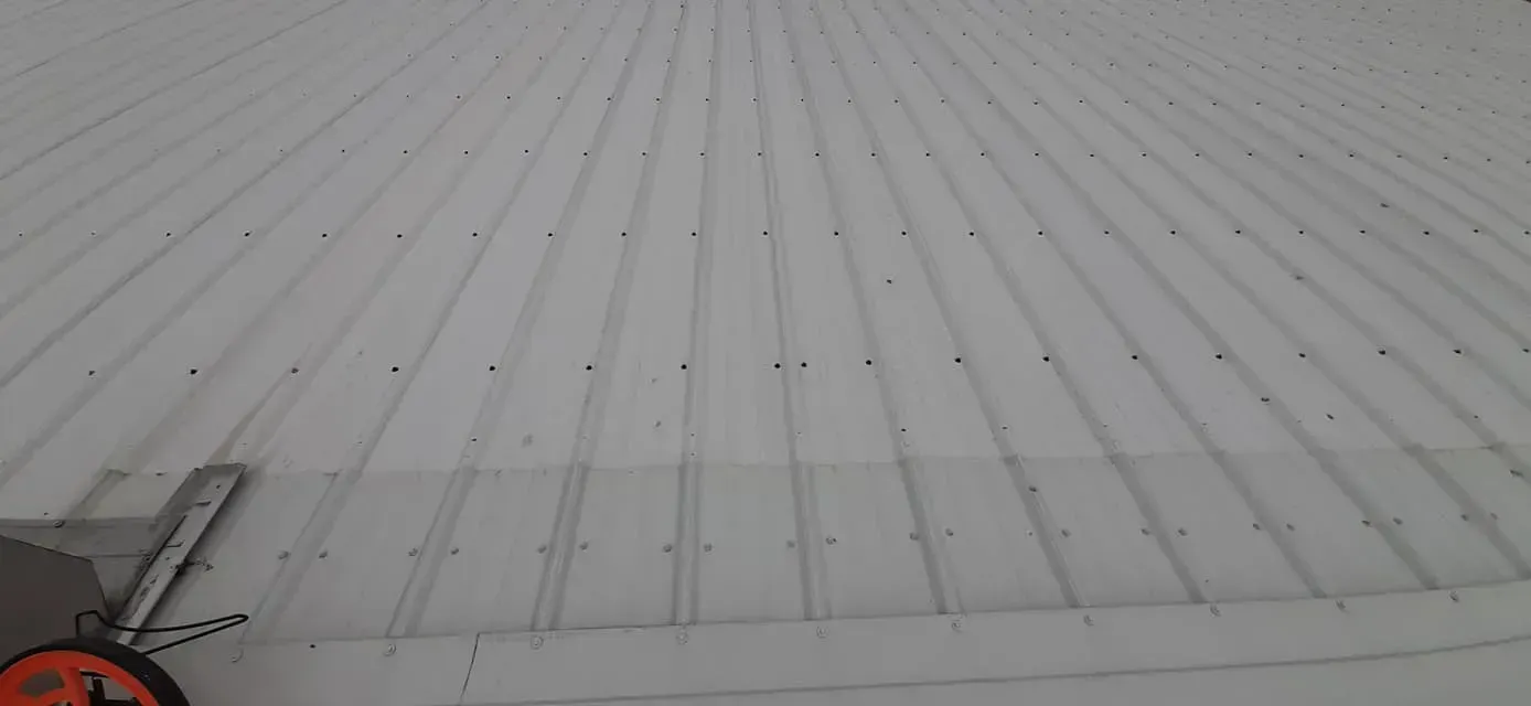 A tape measure is sitting on top of a white roof.