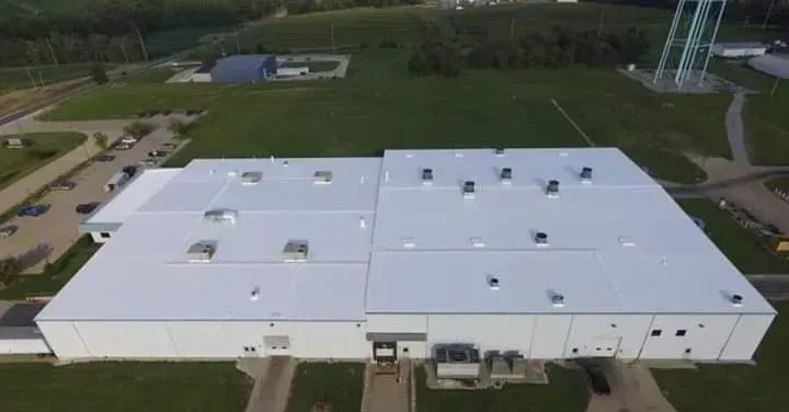 An aerial view of a large white building with a white roof.
