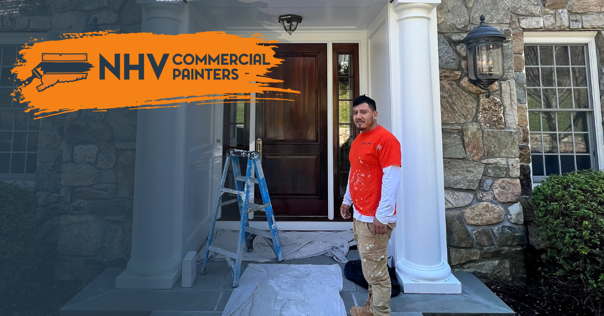 A painter in an orange shirt stands on a porch with a ladder in front of a house, featuring the New Haven Painters logo.