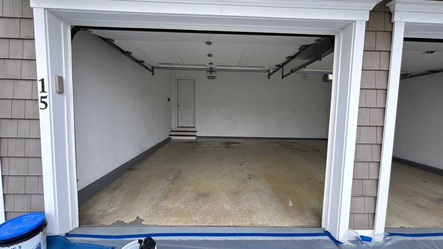 Empty garage with painted walls and floor, open door. Number 