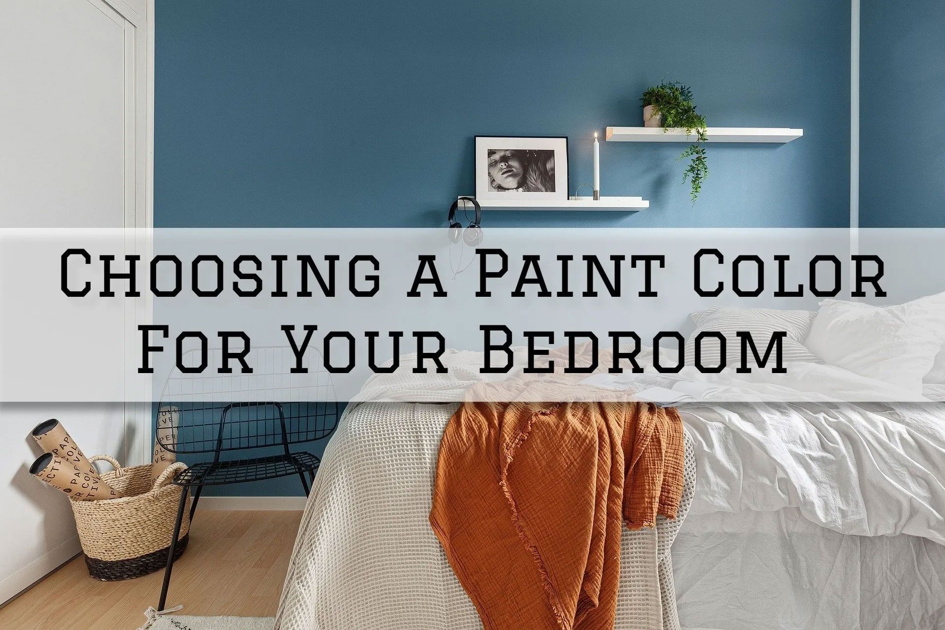 Bedroom with blue accent wall, white bed, wicker basket, and shelf with plants, text: