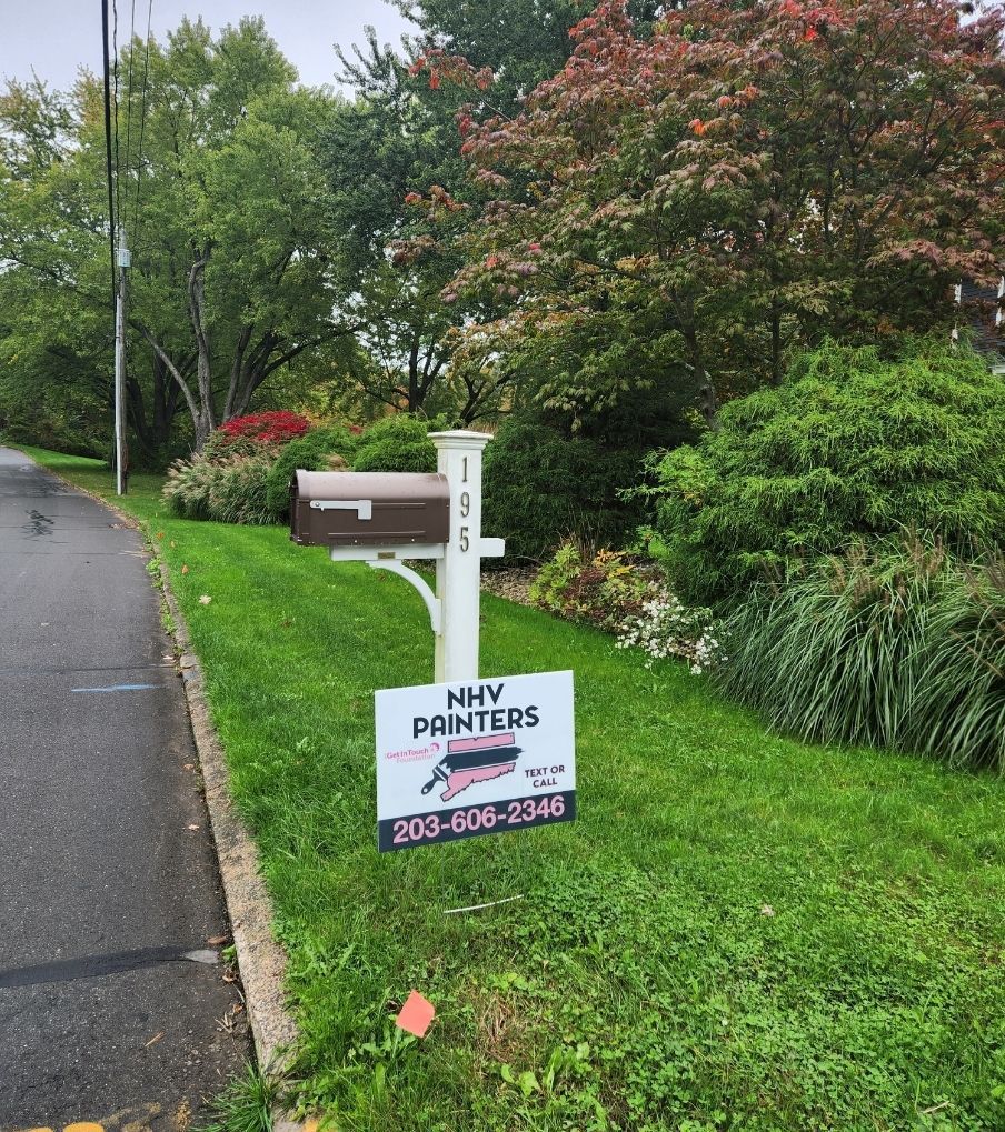 A lawn with a mailbox and sign. Sign says