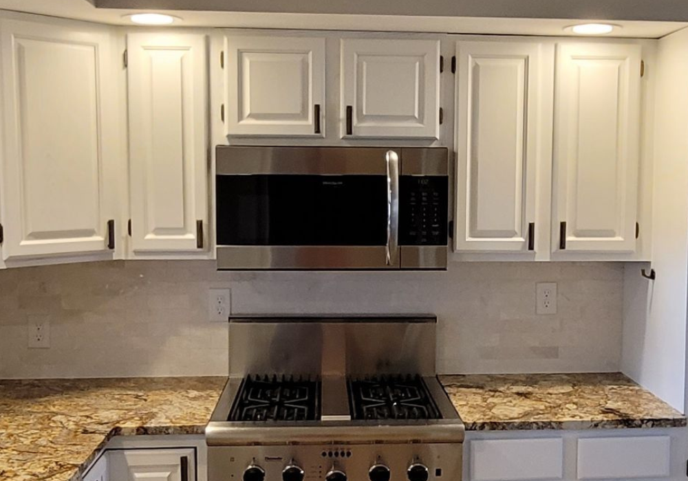 A kitchen with stainless steel appliances and white cabinets
