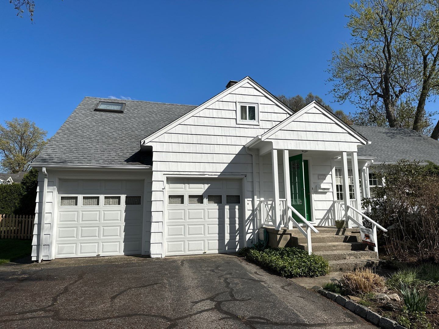 A white house with a garage and a green door