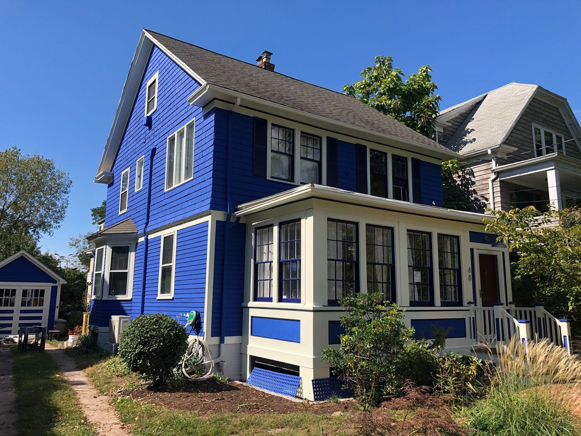 A blue and white house with a large porch