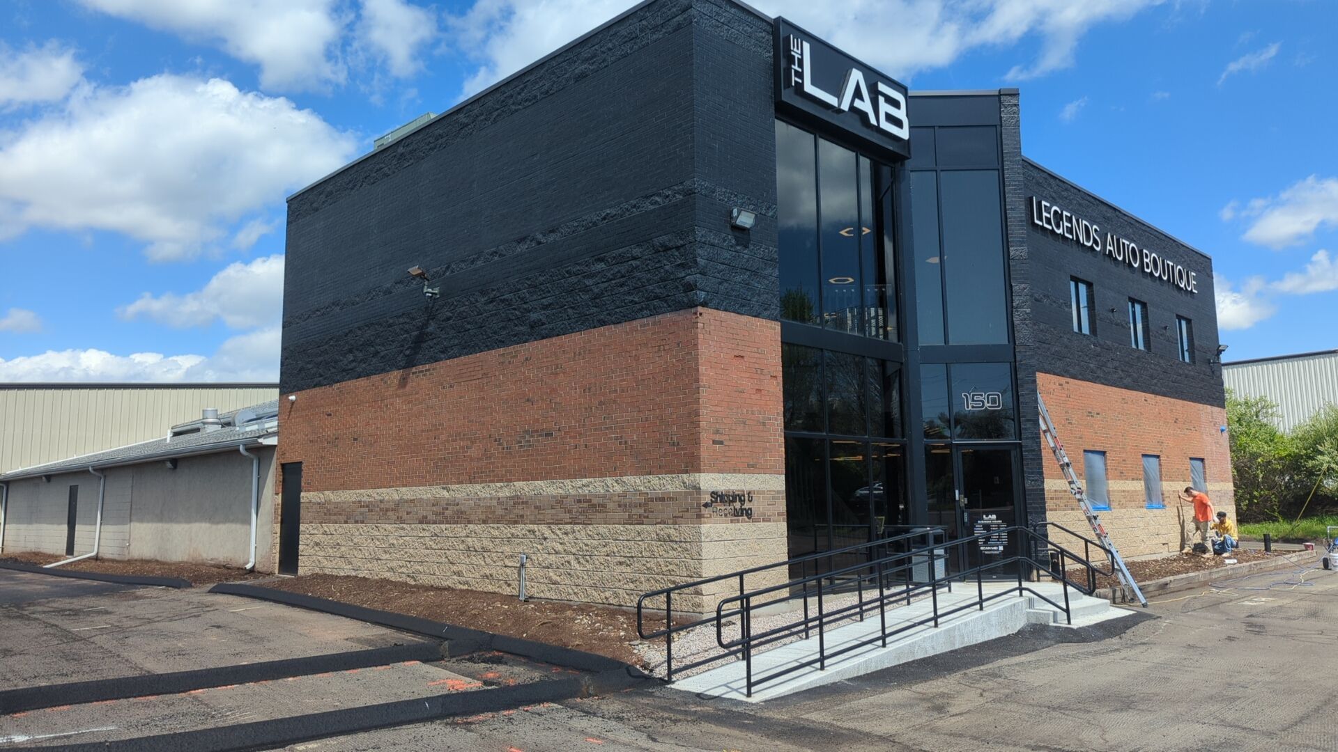 A large black and brick building with a ramp leading to the entrance.