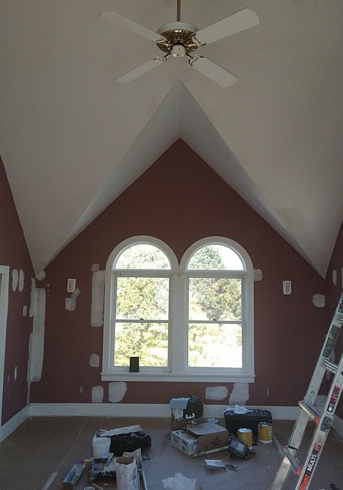A room with a vaulted ceiling and a ceiling fan
