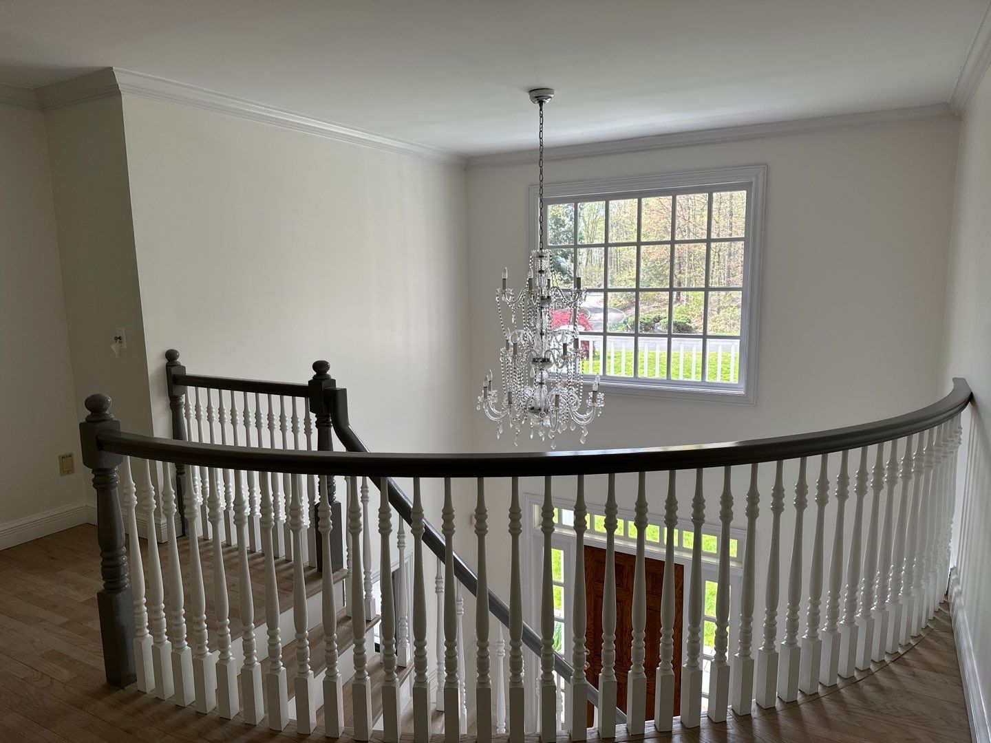 There is a chandelier hanging from the ceiling above the stairs.