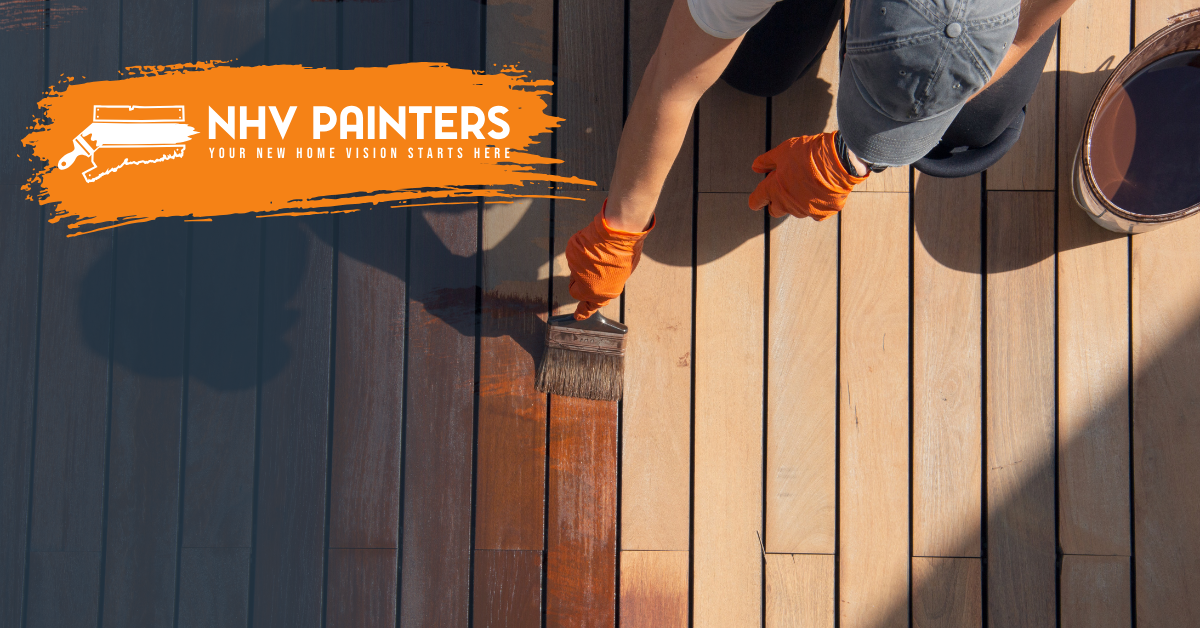 Painter applying orange stain to wooden deck beside NHV Painters logo.