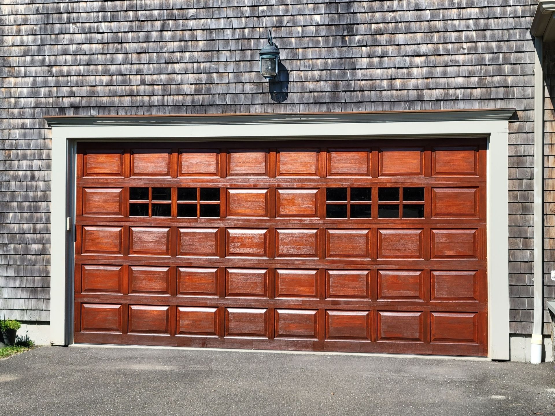 A wooden garage door on a brick building